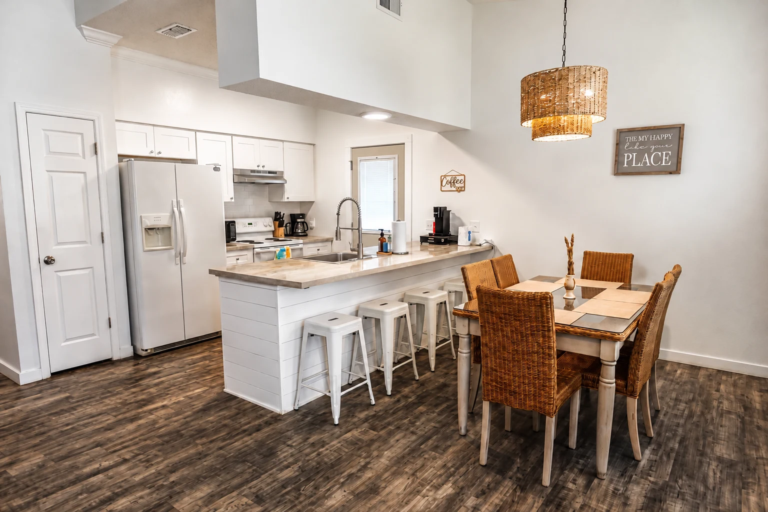 Fully equipped white kitchen with breakfast bar and dining table